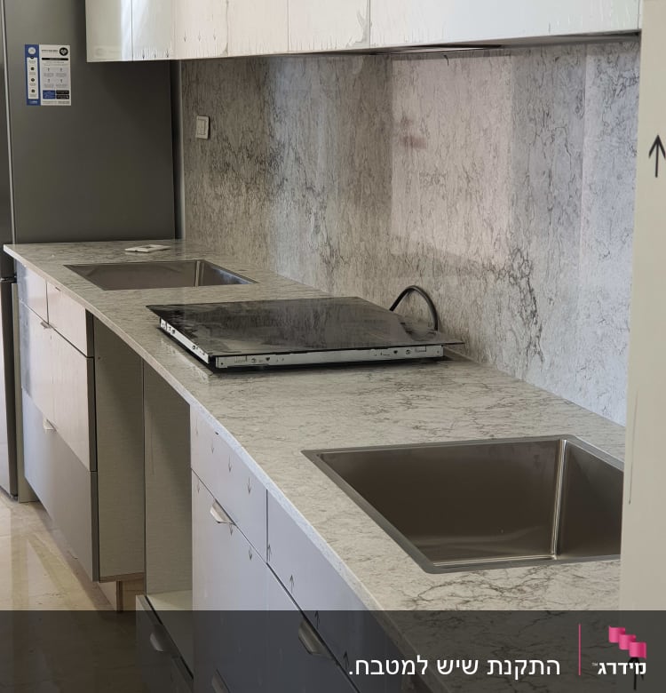 משטח שיש במטבח עם כיור וכיריים